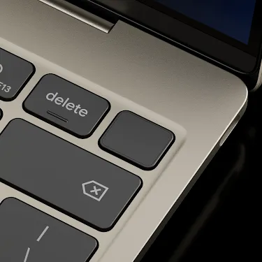 Close-up of the Googlebook keyboard corner showing the power button, volume keys, backspace key, and speakers.