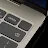Close-up of the Googlebook keyboard corner showing the power button, volume keys, backspace key, and speakers.
