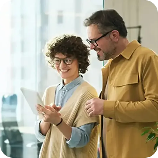 Two work colleagues reviewing information on a tablet at the office.