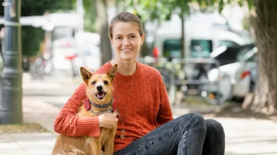 Dogo Founder, Rasa, and her dog, Ūdra, smile for the camera.