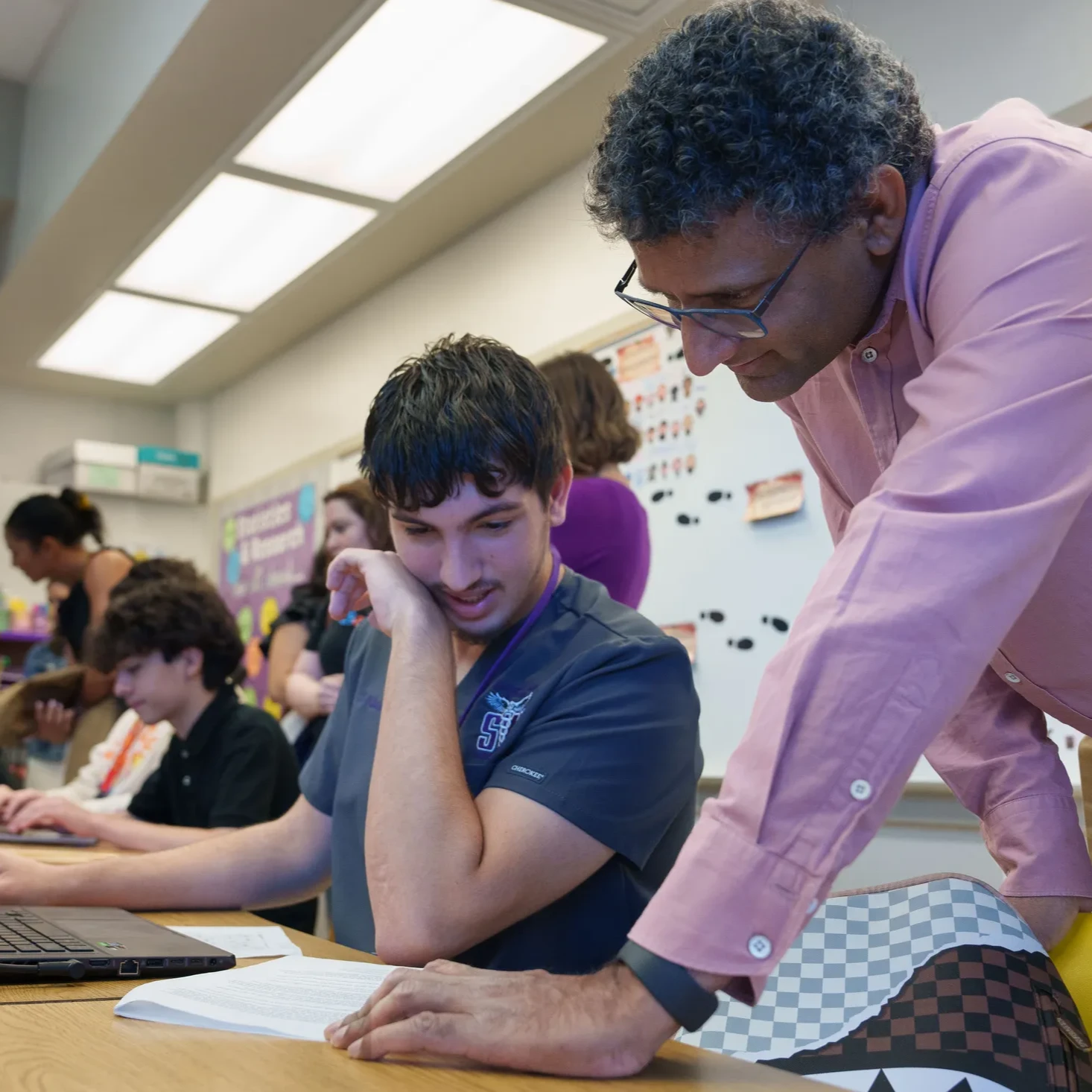 Ben Gomes works with Diosmel González, a high school student, in front of a computer