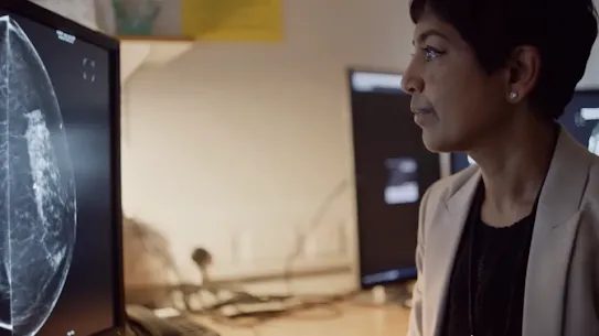 A clinician reviews a digital scan on a monitor.