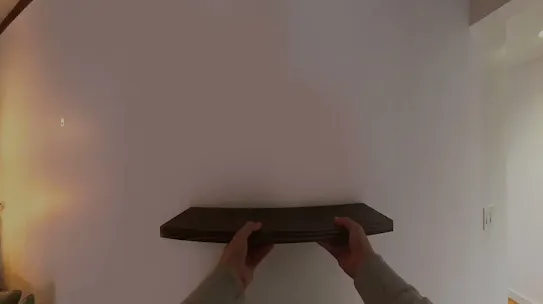 A first-person view of someone installing a shelf on a wall. An overlay asking Gemini the steps to install a shelf. Another overlay appears with the first step, which is to mark the center of the wall.