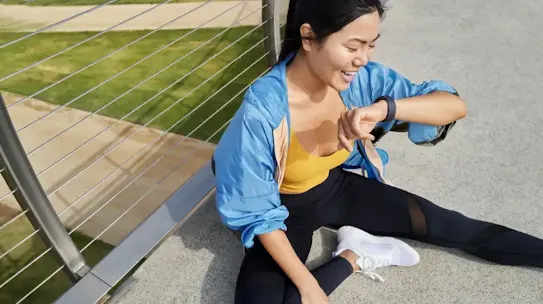 Woman sitting and looking at her smartwatch
