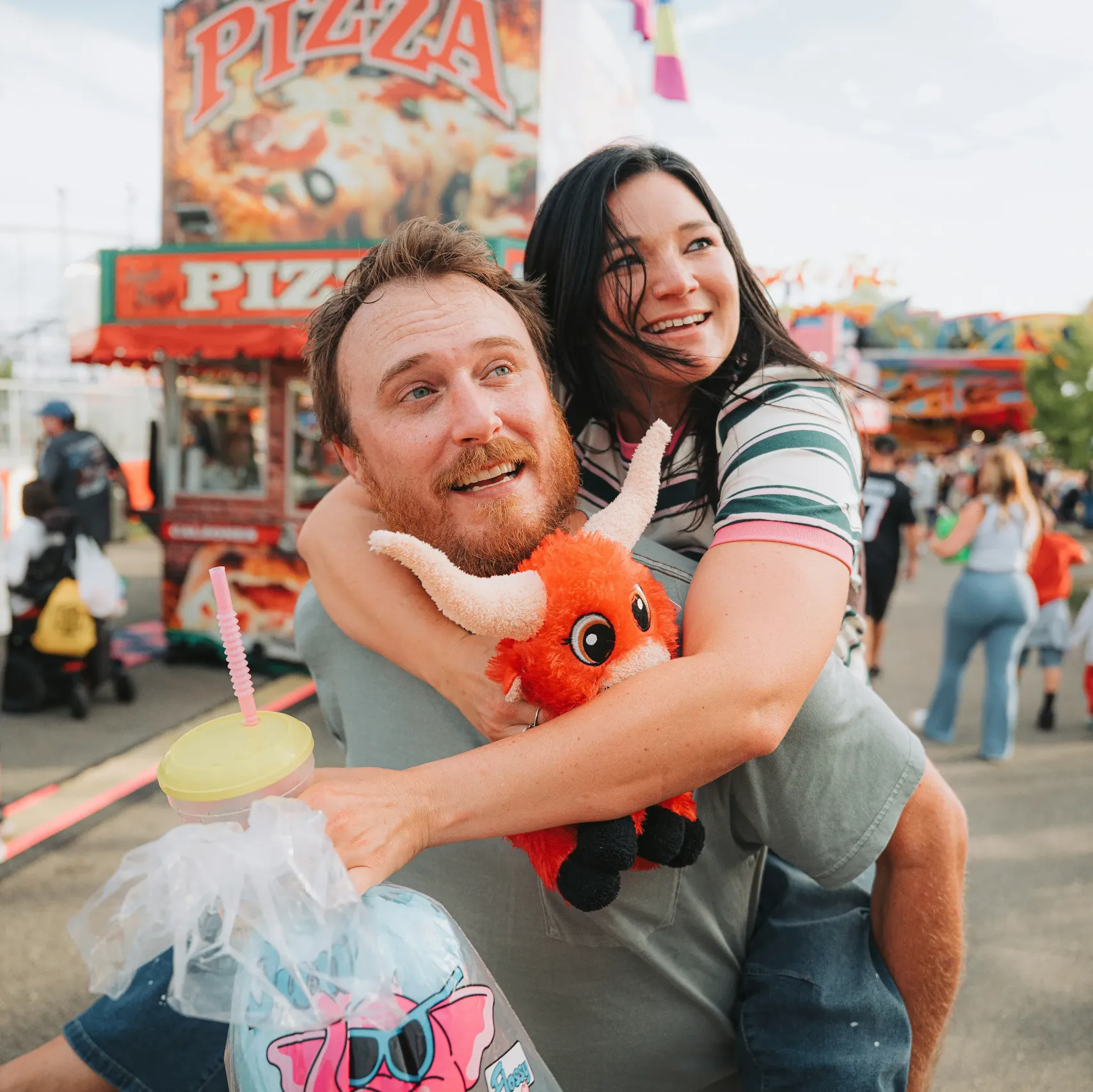 Happy couple hugging at an outdoor festival fairground representing fan traffic management with Waze Event Partners