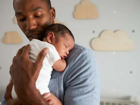 Dad with sleeping baby on shoulder.