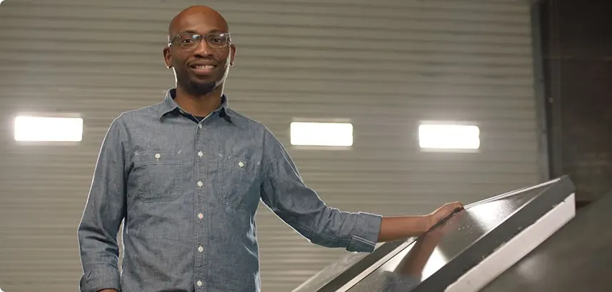 Founder Seyi Fabode smiles at the camera inside his garage-turned-office.