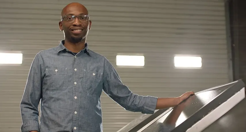 Founder Seyi Fabode smiles at the camera inside his garage-turned-office.