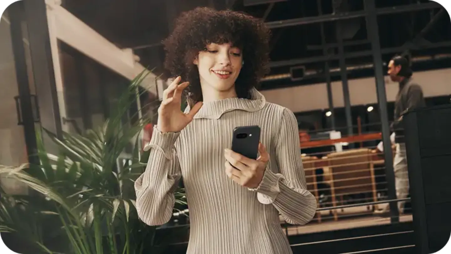 Mulher usando um smartphone e sorrindo.