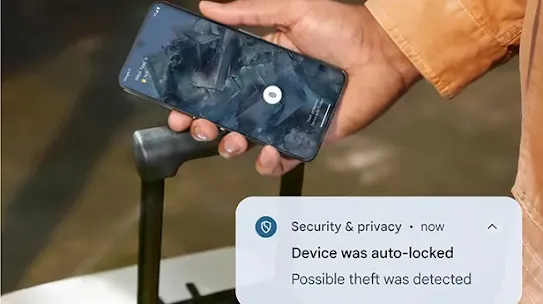 A smartphone displays a security notification that reads, "Device was auto-locked. Possible theft was detected. The phone is being held in a hand near the handle of a rolling suitcase.