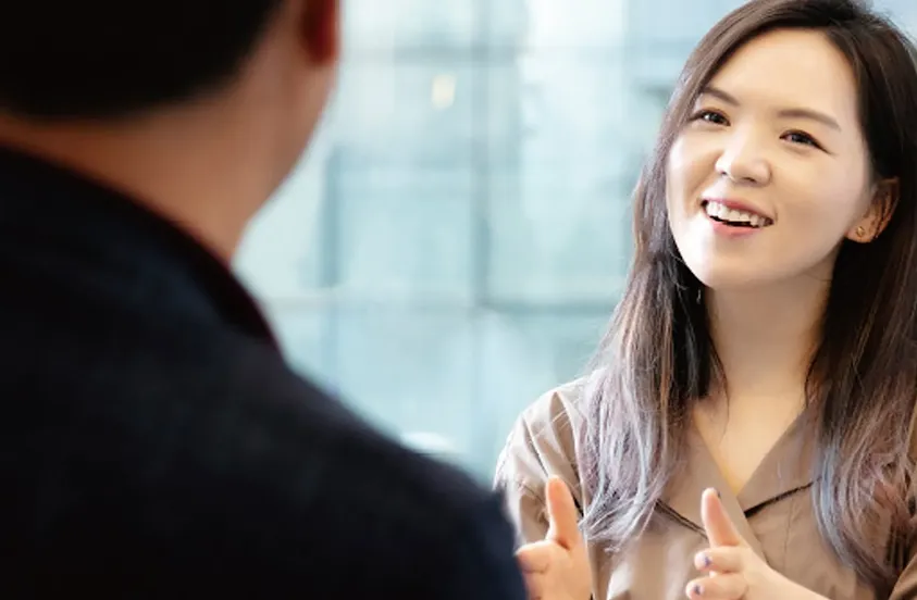 Hanna Kim of Grip smiling while talking to a man