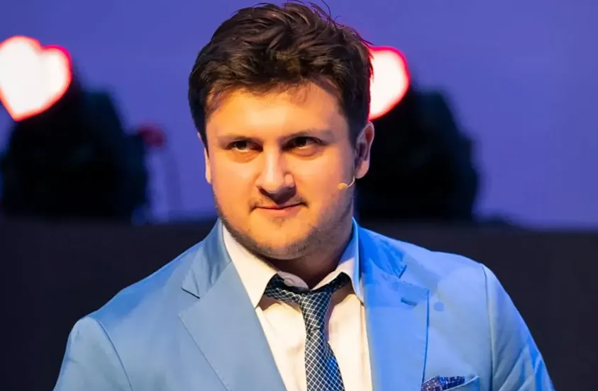 Un hombre con una americana azul y un micrófono de corbata