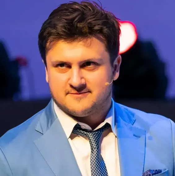 Un hombre con una americana azul y un micrófono de corbata