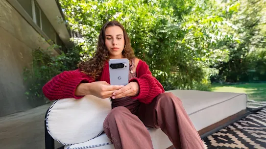 Eine Frau benutzt ihr Smartphone draußen, mit Bäumen im Hintergrund.