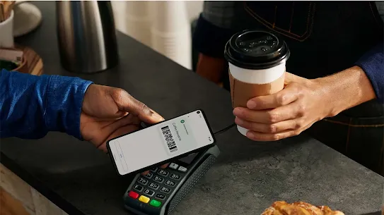 A man purchasing a coffee using Google Wallet as his payment method.