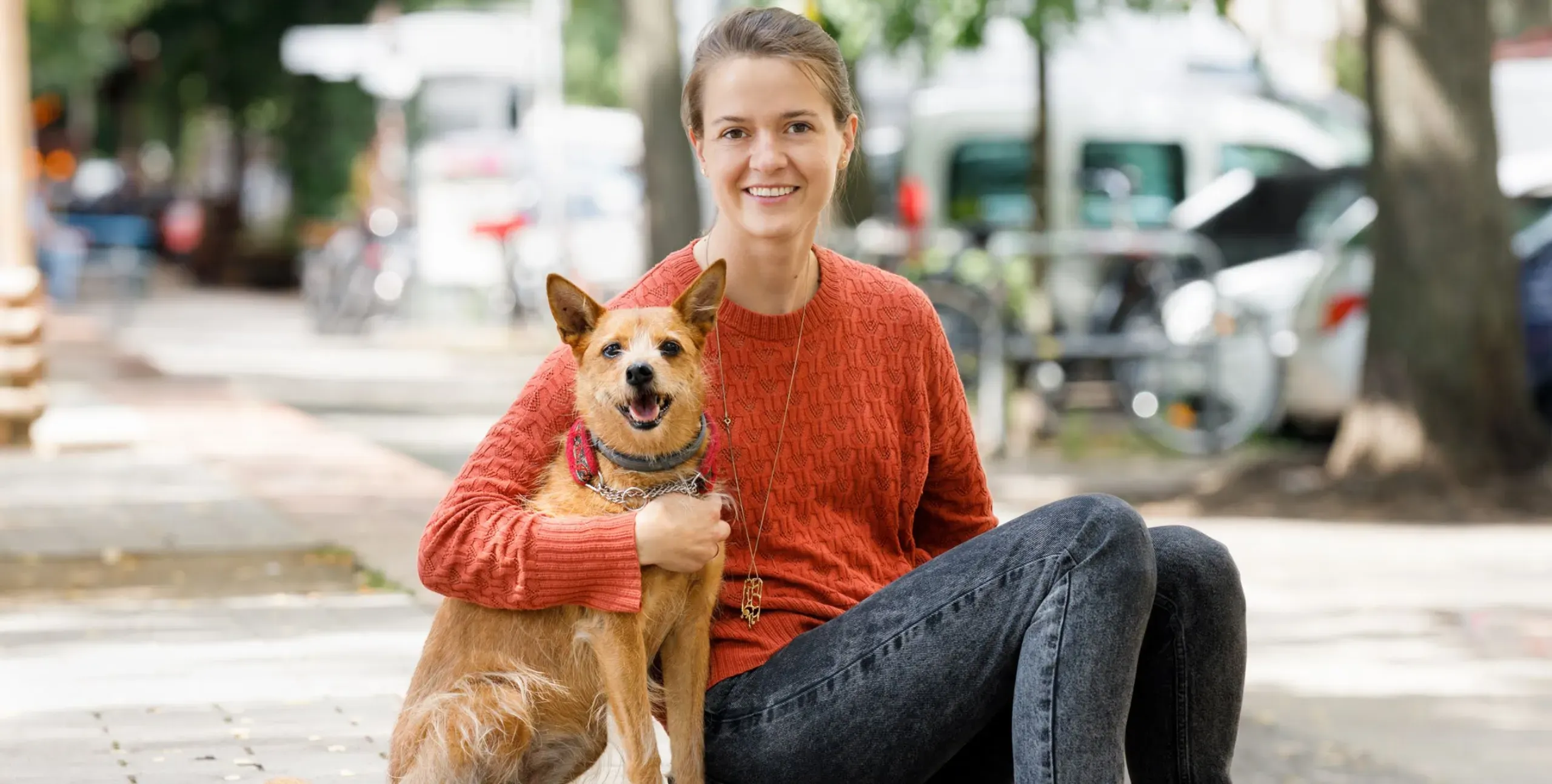 Dogo Founder, Rasa, and her dog, Ūdra, smile for the camera.