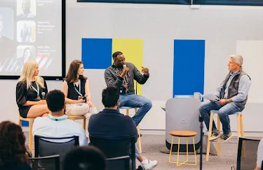A panel of professional is discussing ideas and sharing insights during a conference. session in front of an engaged audience.