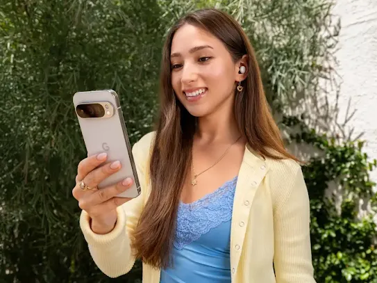 Woman standing in a park looking at her Android phone