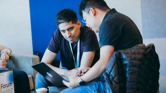 A founder and a Google mentor look at a laptop.