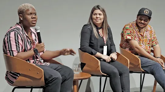 Empreendedores Akin Abaz, Aline Landim e Thiago Vinícius em apresentação no palco