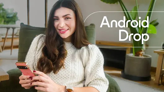 Person sitting in a green chair looking at a coral pixel 11 phone with the words Android Drop.