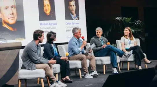 A man talking something and others listening and looking at him.