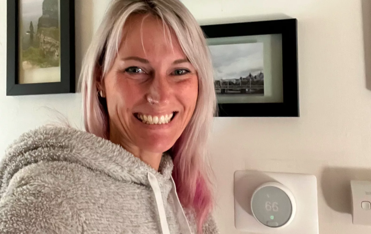 Megan Pell, a Rush Hour Rewards user from Michigan is seen in front of her Google Nest Thermostat in her house