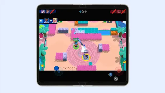Two characters firing at each other in a colorful arena with pools and trees in Brawl Stars on a foldable phone’s screen.