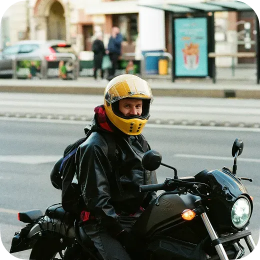 Motorcyclist in a yellow helmet on his bike using Waze motorcycle navigation app