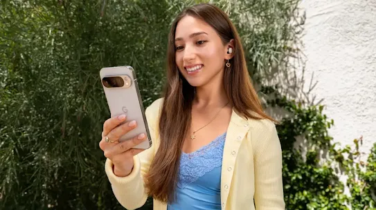 Woman standing in a park looking at her Android phone