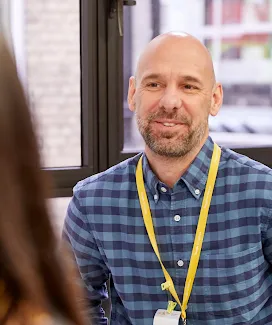 A man talking with a woman while slightly smiling