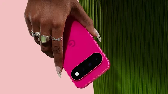 Close-up of a hand with rings holding a bright pink Google Pixel phone.