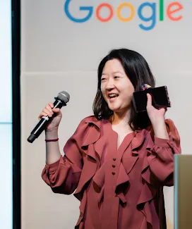 A woman holding mic in one hand and mobile in second hand