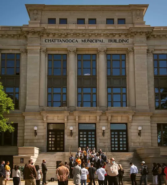 A crowd of people and officials gathered for an event on the front steps of the historic Chattanooga Municipal Building in Tennessee.