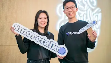 From L-R female co-founder Hyeonji Hwang and male co-founder Jeongmin Lee, posing with the Smoretalk signage