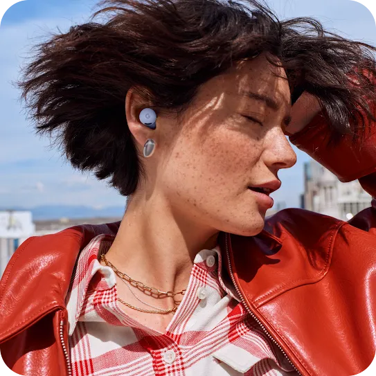 A person dances with earbuds on. 