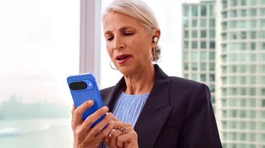Woman using a Pixel 10 device in an office. Through the window, you can see a building in the background.