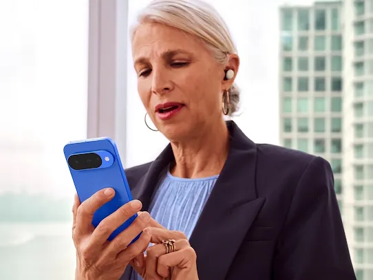 Woman using a Pixel 10 device in an office. Through the window, you can see a building in the background.