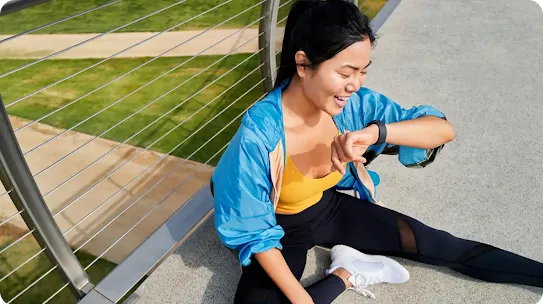 Woman sitting and looking at her smartwatch