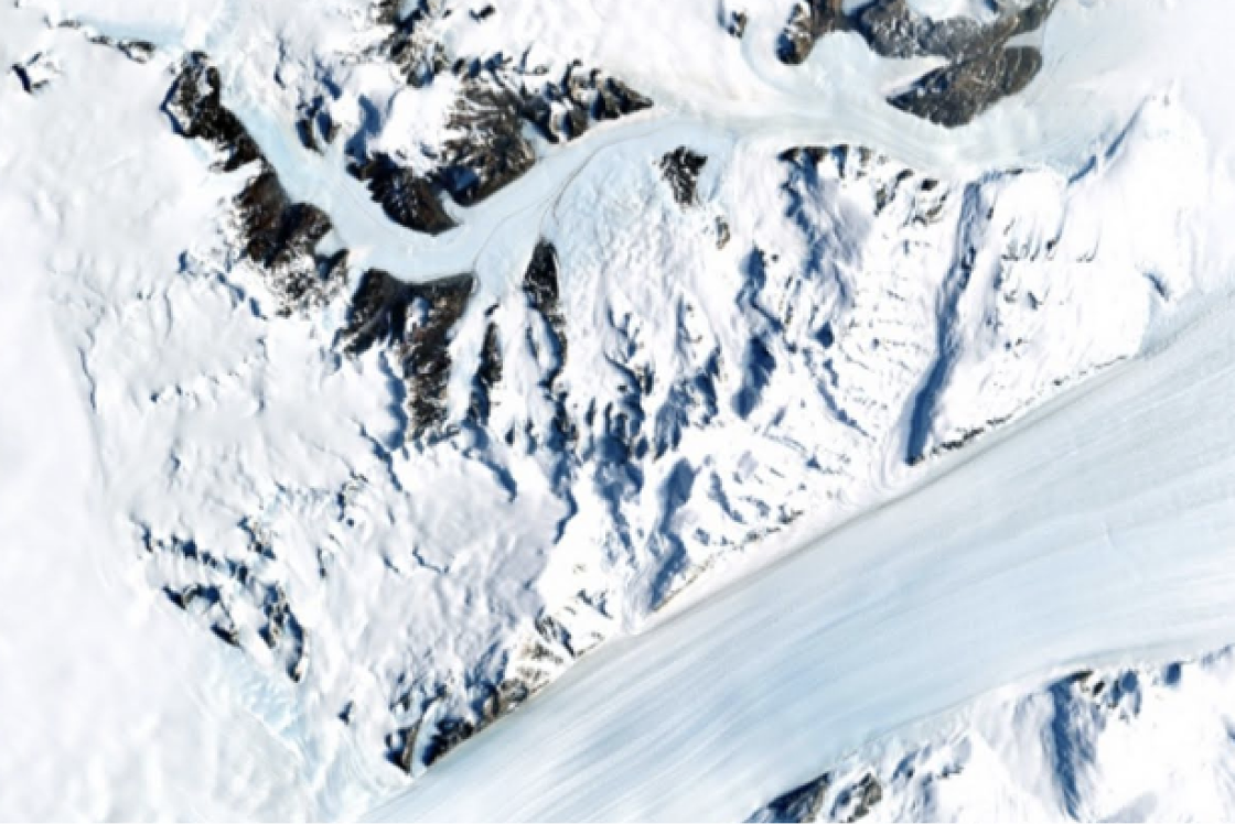 Flugaufnahme von einer nicht geschlossenen Schneedecke, die das Schmelzen der Gletscher dokumentiert