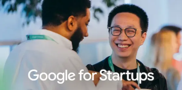 Two professionals conversing and smiling at an event, with the Google for Startups logo overlay.