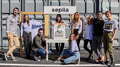 The team of Sepiia pose in front of their sign outside.