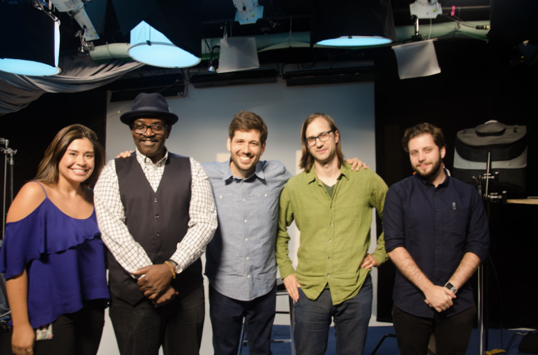 Photograph of 5 people smiling on a film set