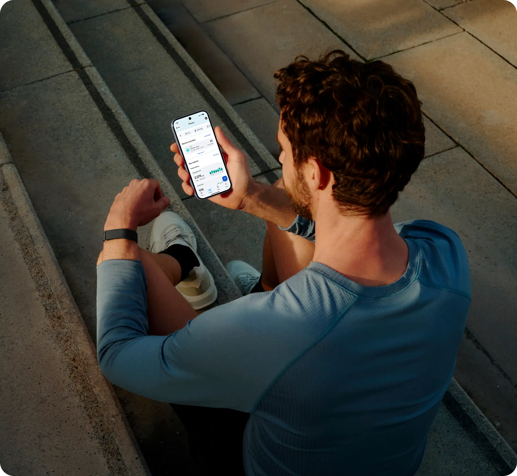Image of man wearing Google Fitbit Air and using the Google Health App.