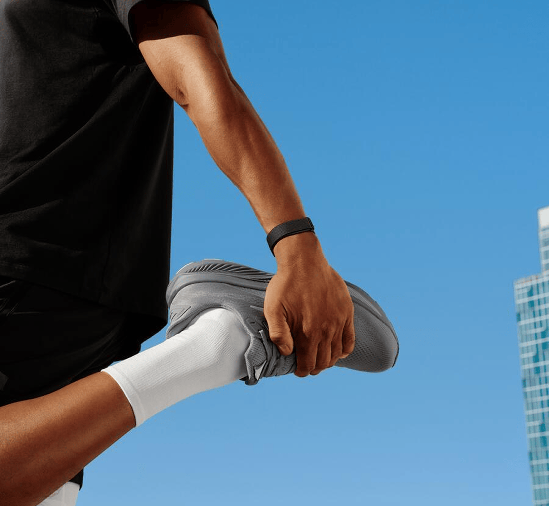 Image of man stretching wearing Google Fitbit Air.
